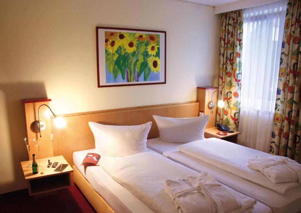 维林根加尔尼典雅酒店的酒店客房设有两张床,墙上挂着一张照片。