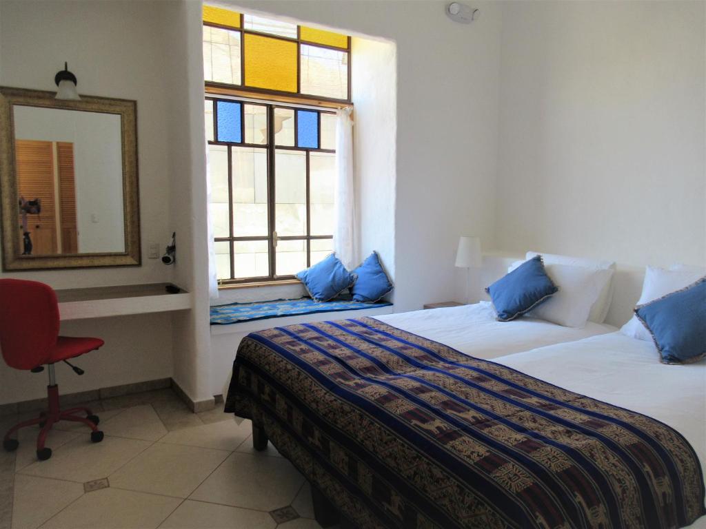 阿里卡Apartamento Terra Amata Arica的一间卧室配有两张床、镜子和椅子