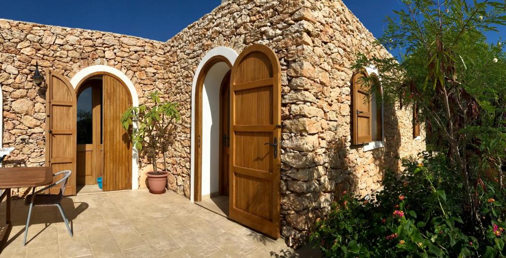 兰佩杜萨Dammuso Villa的石屋,设有木门和庭院