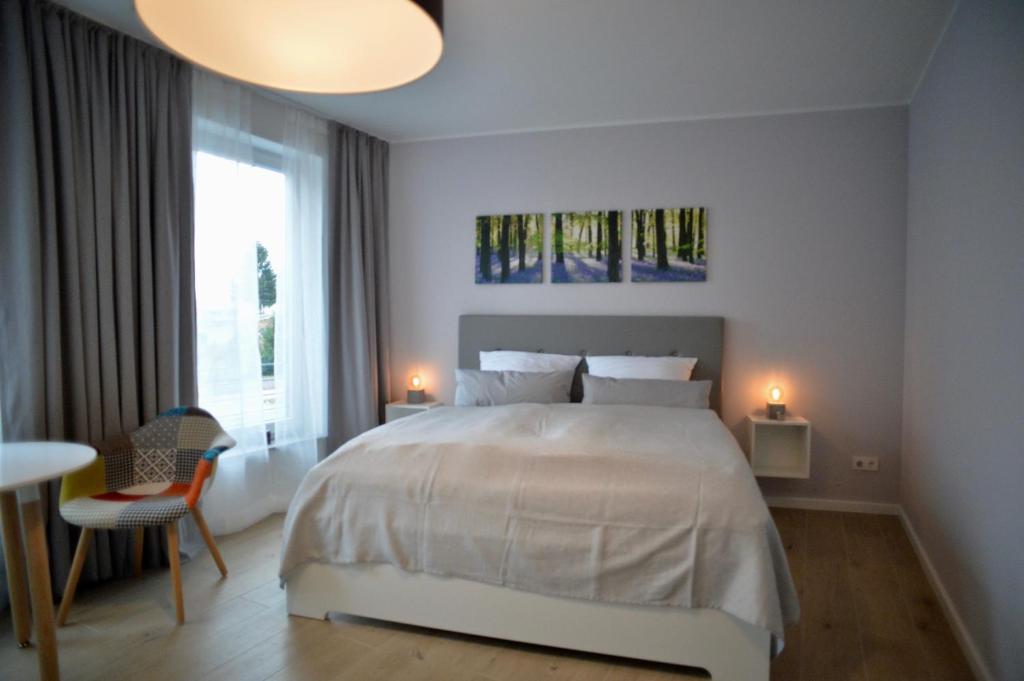 格罗斯贝伦Grey House Apartments Grossbeeren的白色的卧室设有一张大床和一个窗户