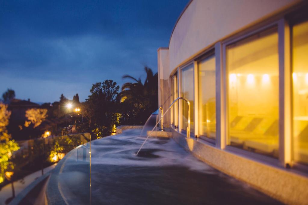 西尔米奥奈Olivi Hotel & Natural Spa的一座建筑,在晚上窗户边