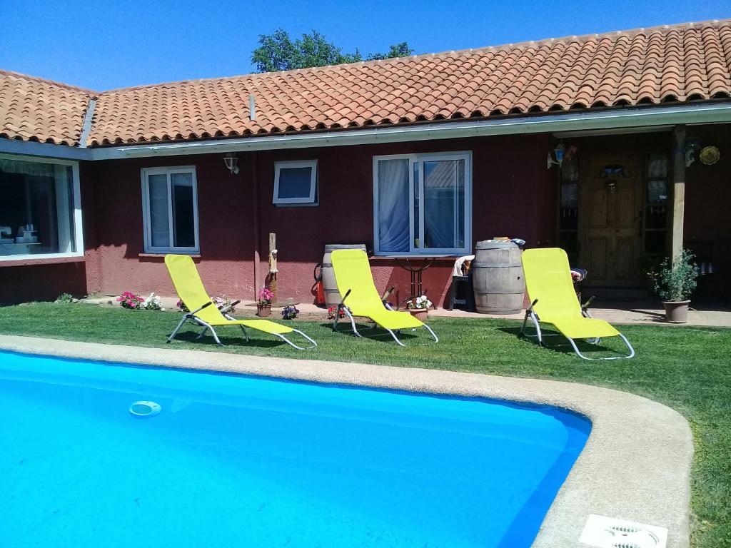 兰卡瓜Alojamiento Los Nogales的一组椅子和一个位于房子前的游泳池