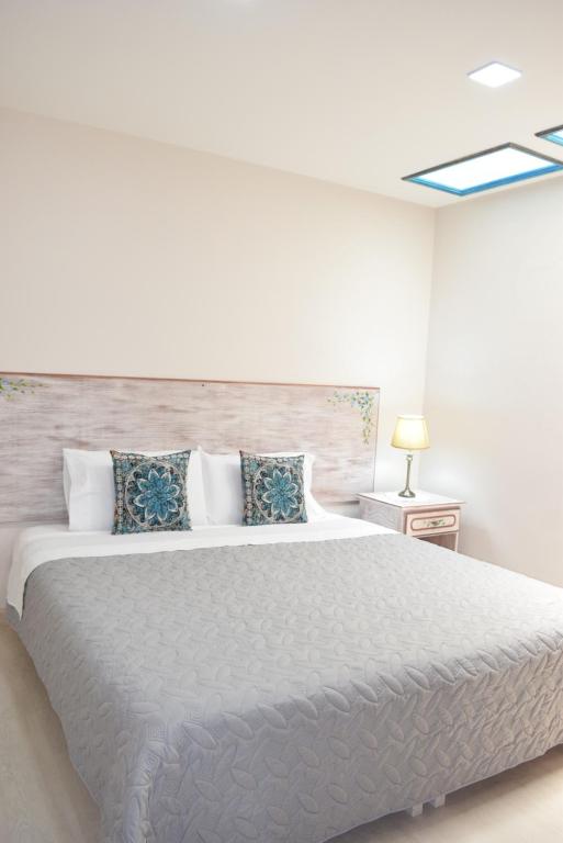 昆卡La Casa Azul的白色卧室配有一张带枕头的大白色床