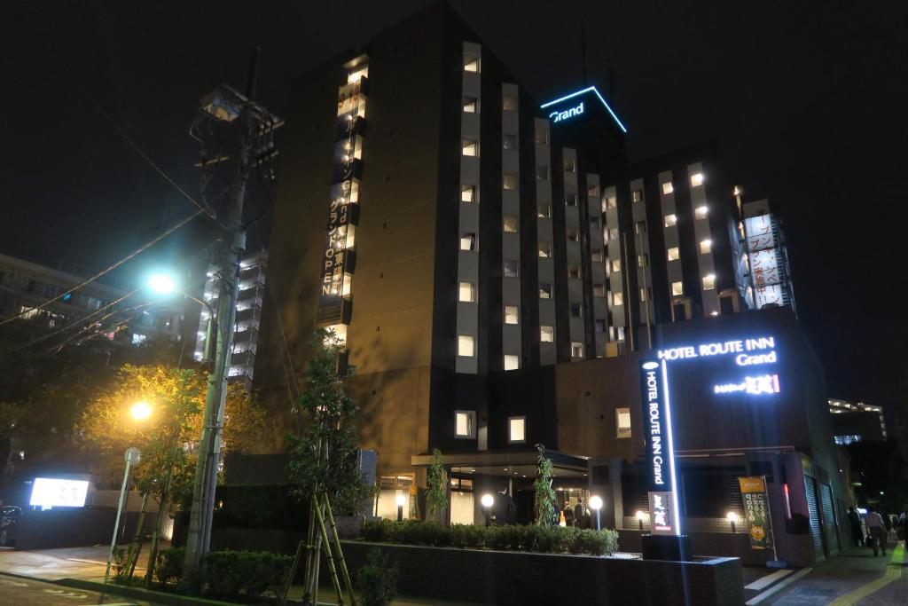东京东京东阳町站大酒店的一座高大的建筑,晚上在前面有标志