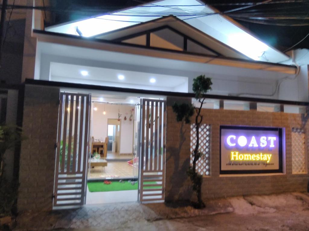 绥和市Coast Homestay的房屋前门,有标志