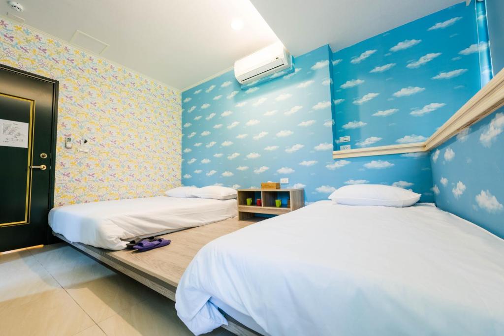 Ruifang瑞芳老街-嫚嫚窝民宿的蓝色墙壁客房的两张床