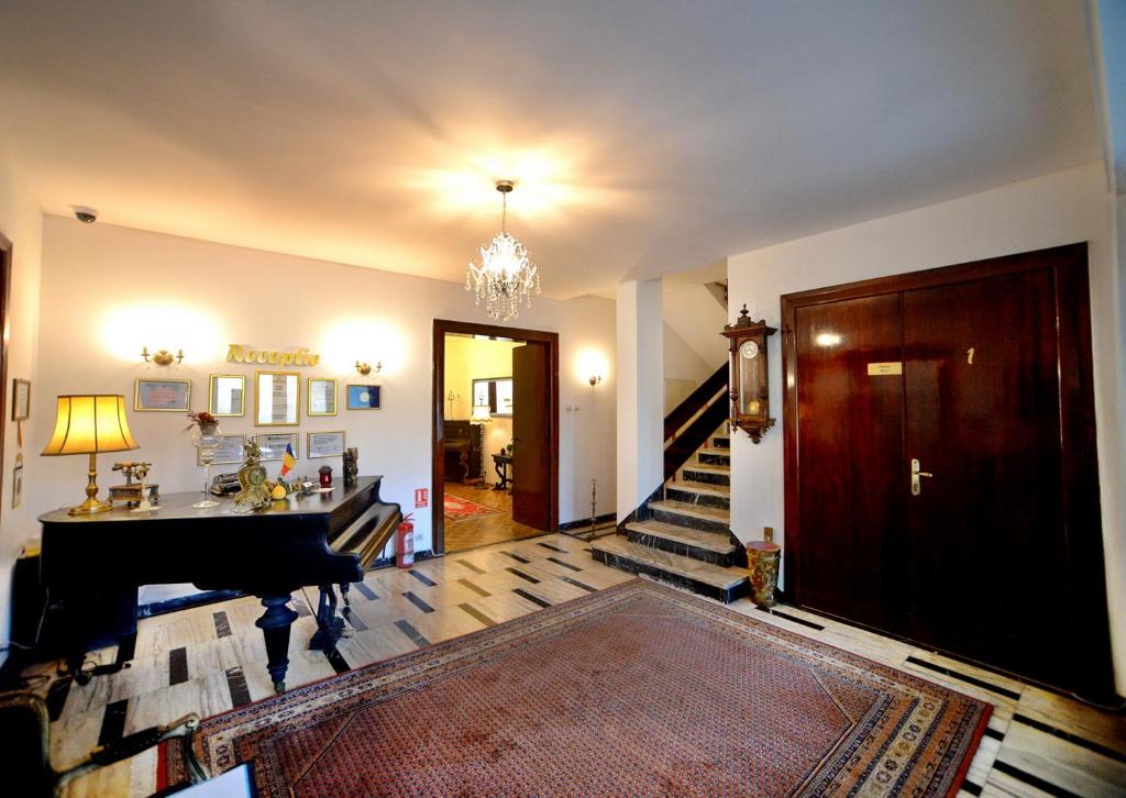德瓦Casa Negustorului的客厅设有三角钢琴和楼梯