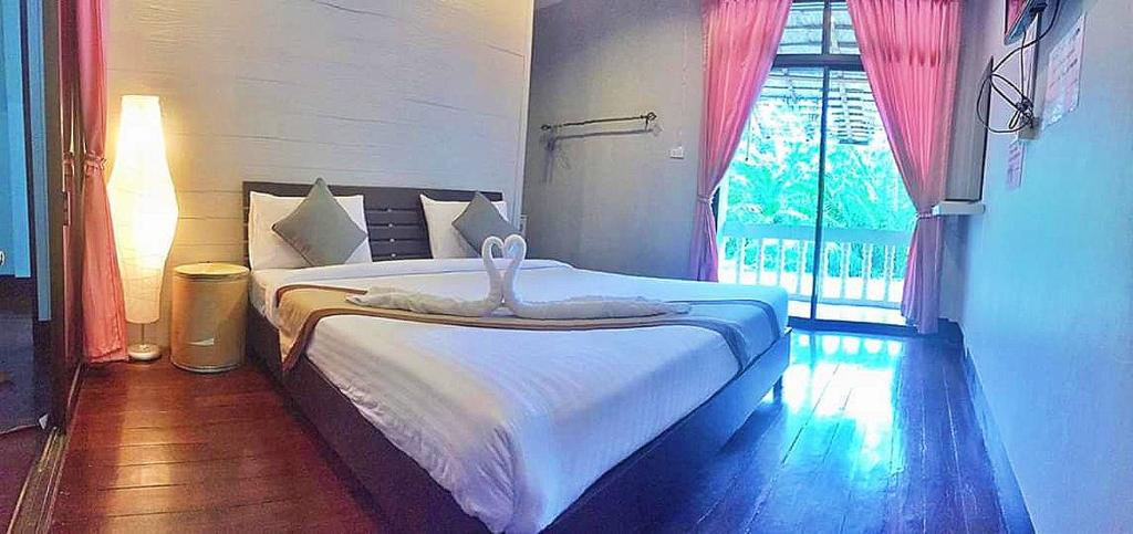 高兰Marina hut guest house的卧室配有白色的床和窗户