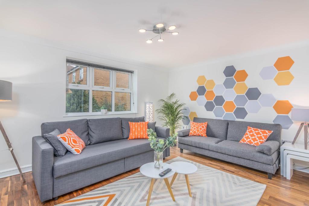 赫默尔亨普斯特德Wing House的客厅配有2张灰色沙发和橙色枕头