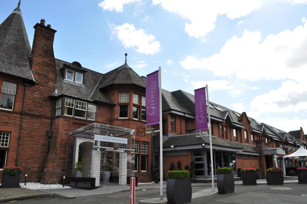 伦弗鲁Glynhill Hotel & Spa near Glasgow Airport的前面有紫色标志的建筑