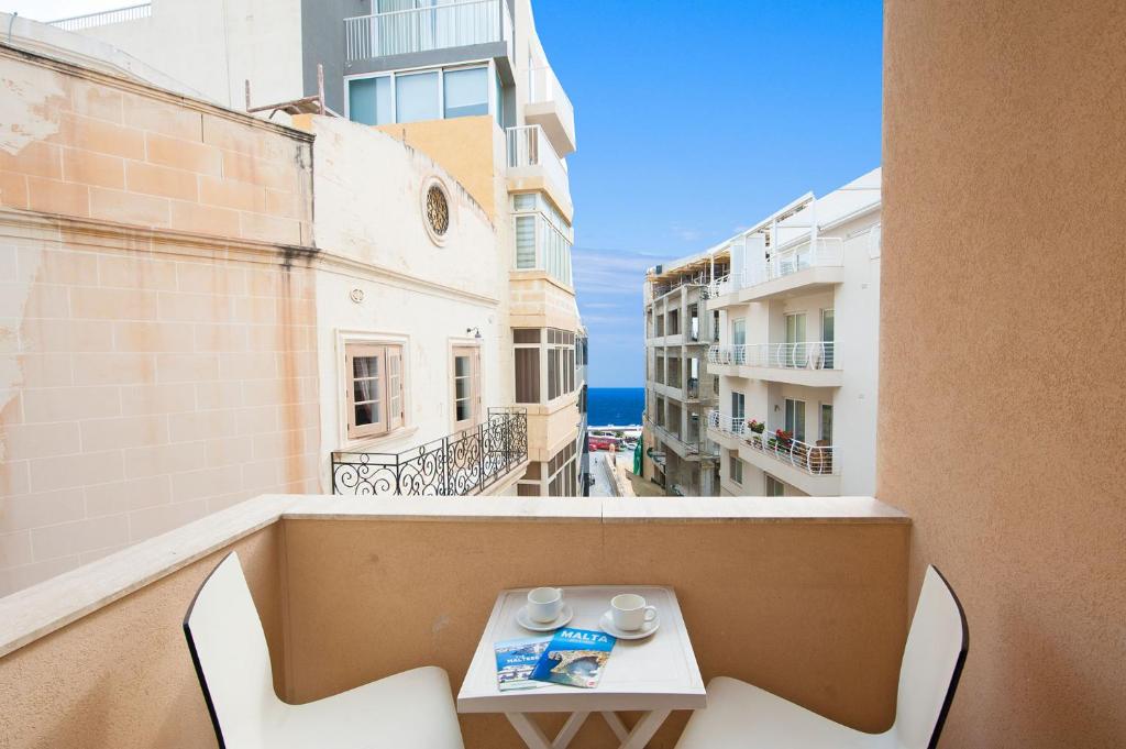 斯利马阿尔博拉大公寓酒店的大楼内的阳台配有桌椅