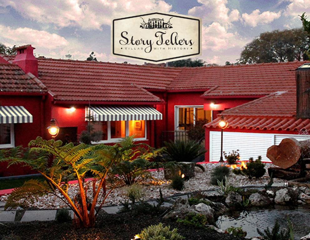 辛特拉Storytellers Villas的红色的建筑,上面有读到睡眠的大堂的标志