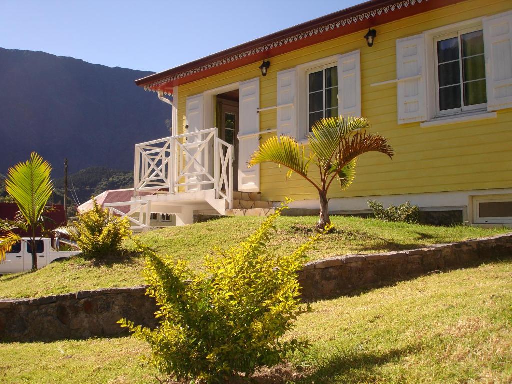 锡拉奥CÔTE MONTAGNE的一座黄色房子,前面有一棵棕榈树