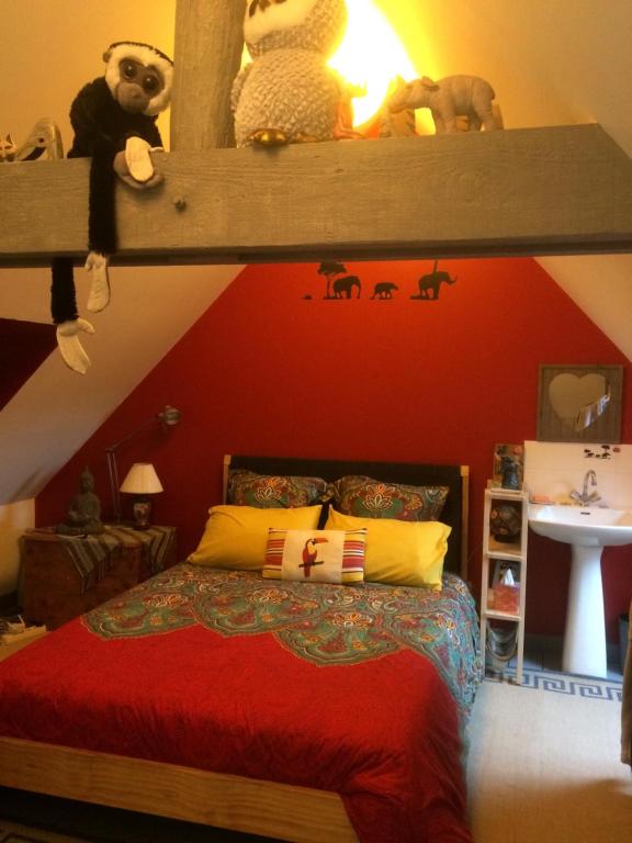 圣艾尼昂Le petit secret的一间卧室配有一张红色墙壁的床