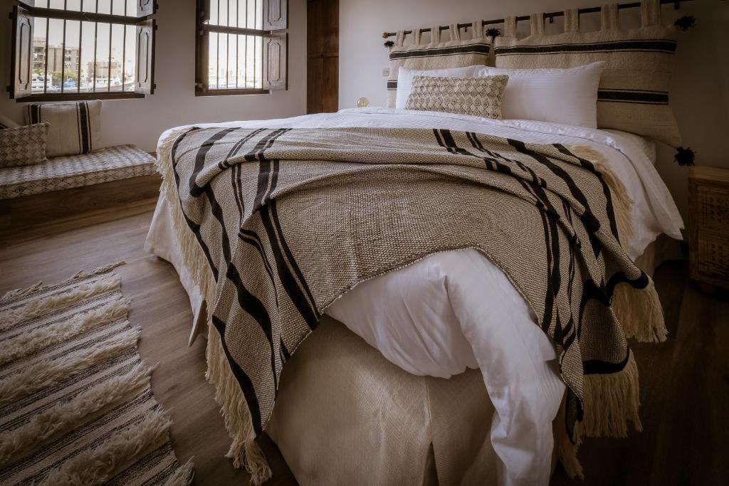 迪拜MAZMI CASA的一间卧室配有一张床铺,床上有毯子