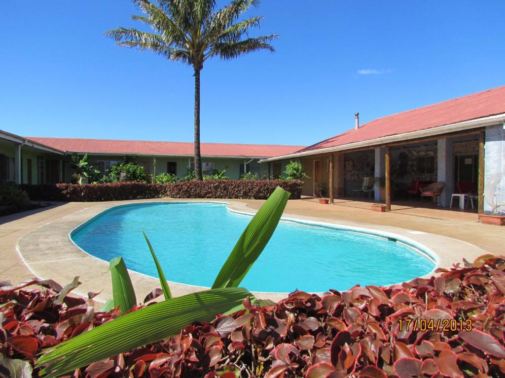 安加罗阿马努特拉酒店的棕榈树建筑前的游泳池