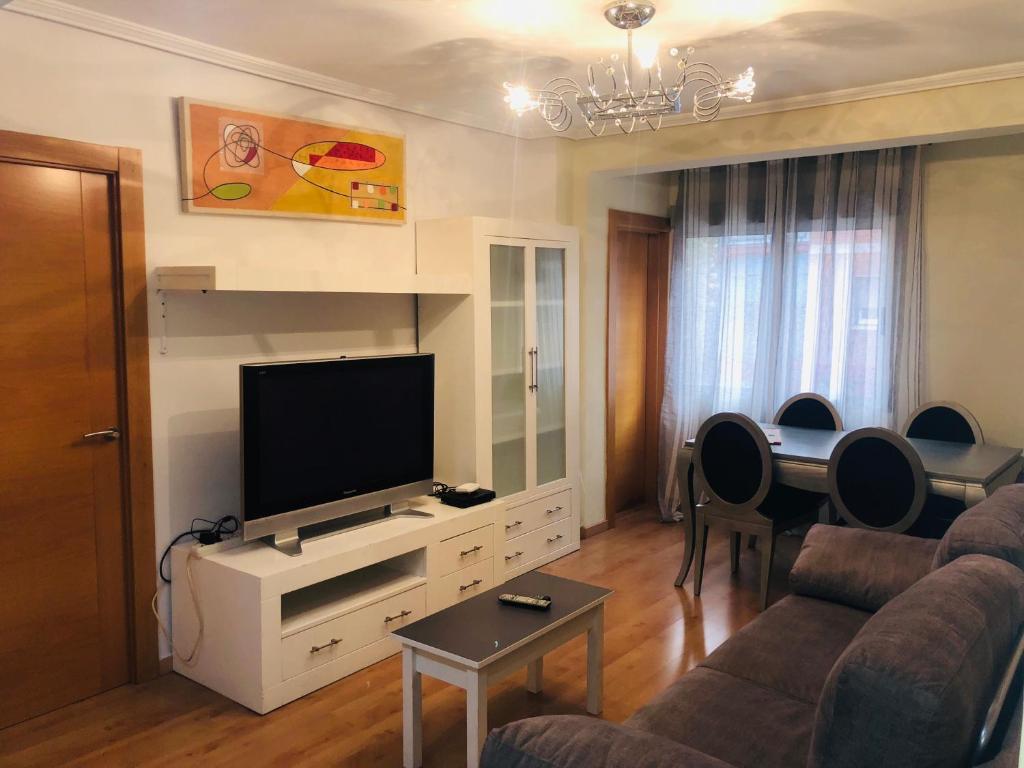 萨拉戈萨Piso Avenida de Madrid的客厅配有电视、沙发和桌子