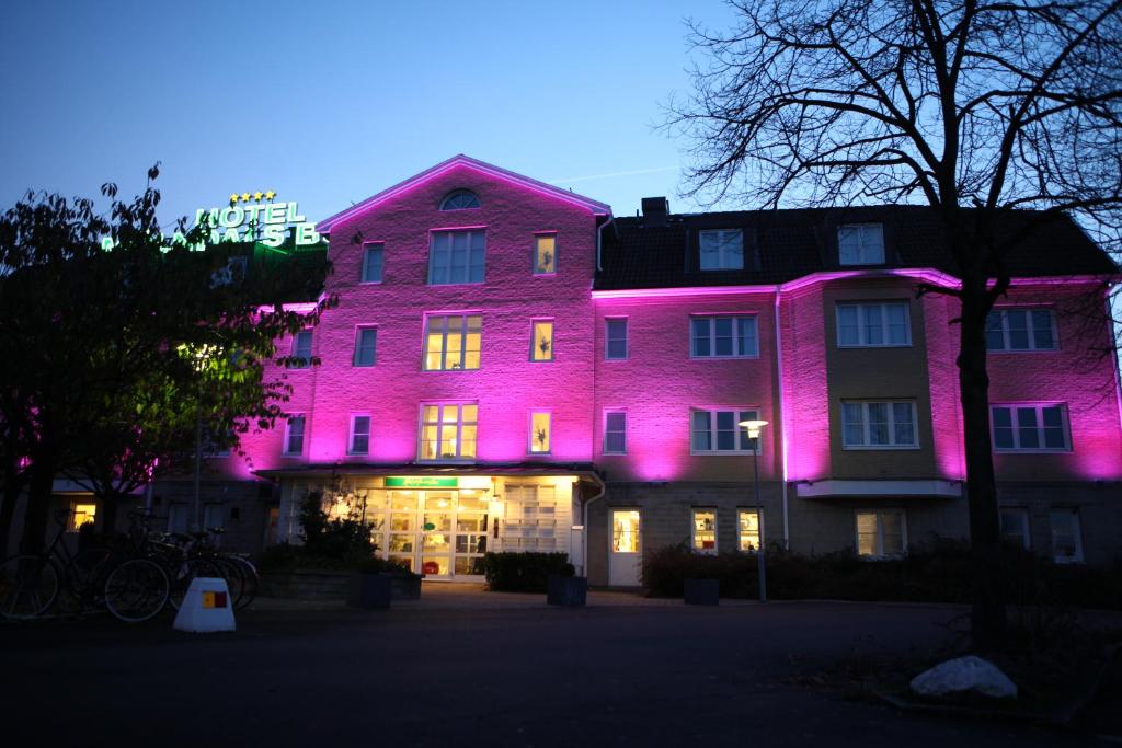 默恩达尔莫达兹兄弟酒店的建筑的侧面有粉红色的灯