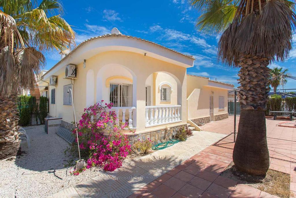 克萨达城CH Villa Isla Menorca Ciudad Quesada的前面有棕榈树的房子