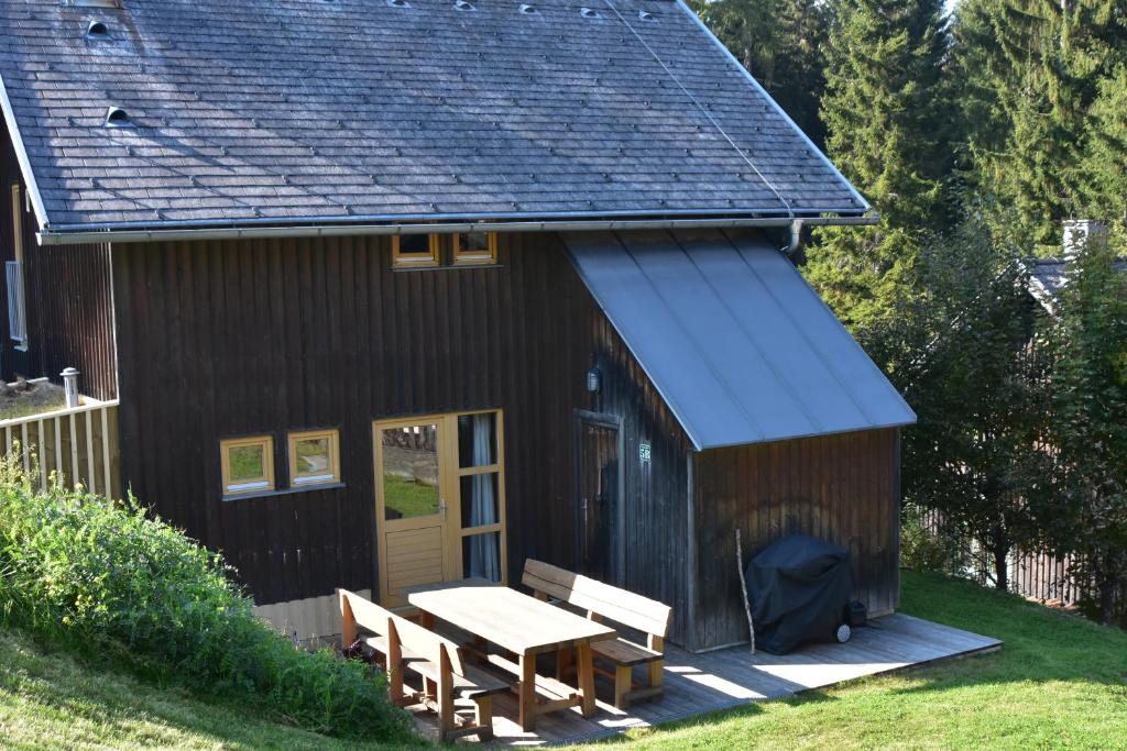 VerditzVerditzhütte的小屋设有野餐桌和蓝色屋顶