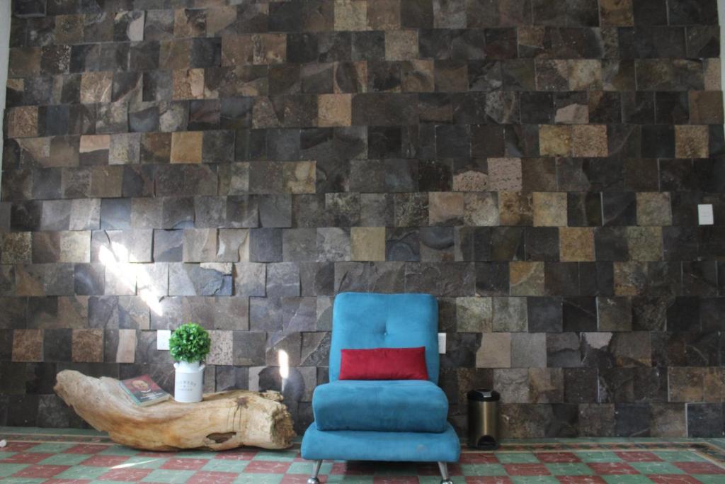 韦拉克鲁斯Casa en el centro de veracruz的石头墙房里的一张蓝色椅子