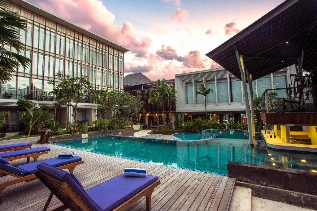 努沙杜瓦努沙杜瓦勒里那酒店的一座带椅子的度假游泳池以及一座建筑