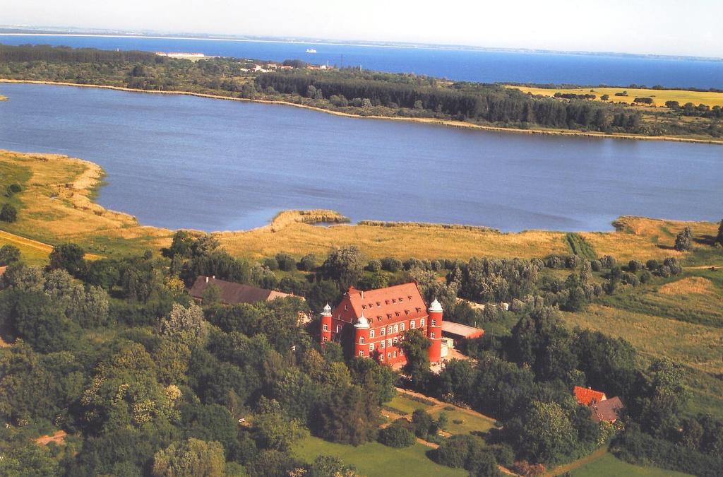 格洛韦施比克城堡酒店的享有湖畔山丘上房屋的空中景致