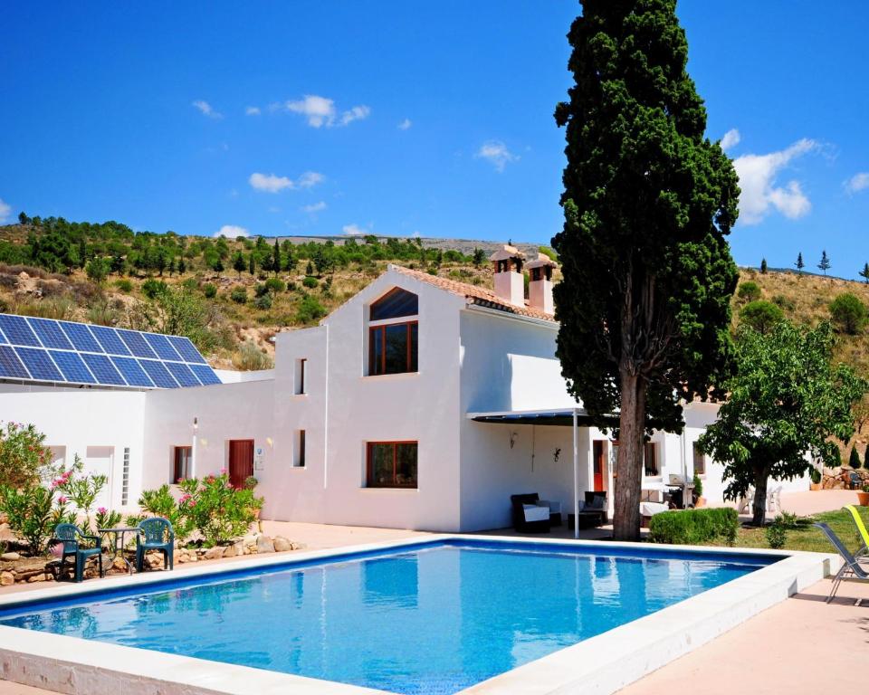 LecrinLa Fuente Retreat的一座带游泳池的别墅和一座带太阳能电池板的别墅