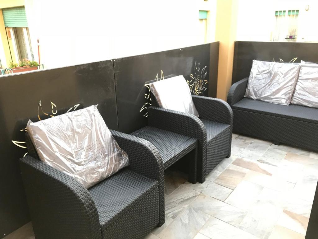 博洛尼亚B&B ATTICO GALLIERA的两张藤椅和一张带两个枕头的长凳