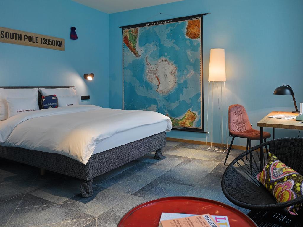 美因河畔法兰克福特瑞普25小时酒店的卧室配有一张床,墙上有地图