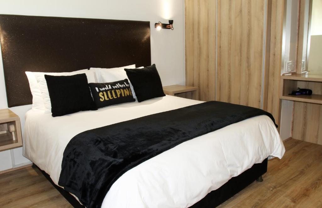 开普敦205 New Cumberland的一间卧室配有一张大床和黑色床头板