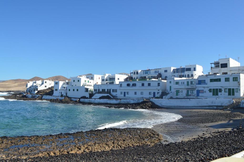 Caleta de CaballoCasa Cabrera - 2 apartamentos con vistas al mar的海滩上的白色建筑群