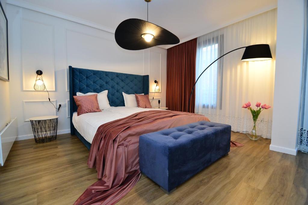 布拉戈耶夫格勒Boutique Apartments Blagoevgrad的一间卧室配有一张大床和蓝色的软垫床头板