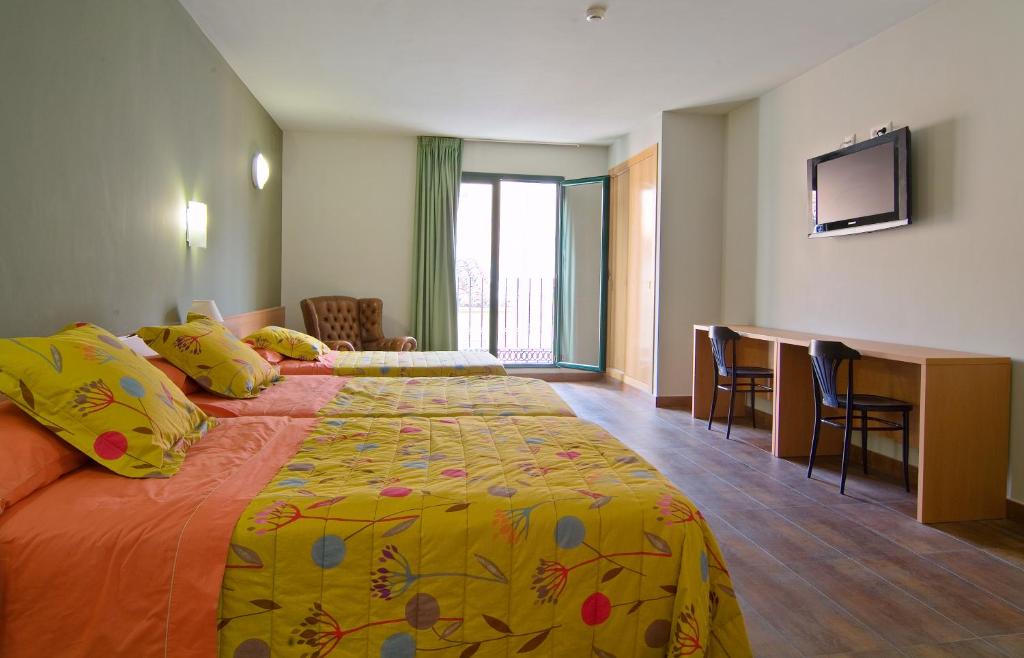 圣科洛马·德法尔品克斯酒店的酒店客房设有一张大床和一张书桌。