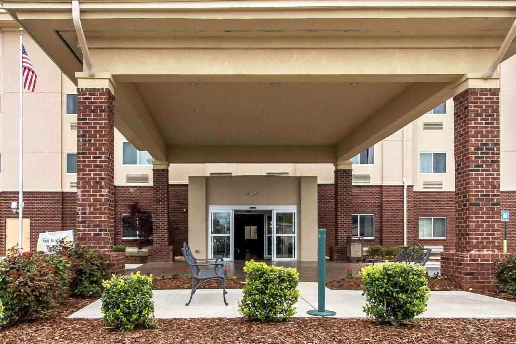 亨茨维尔Sleep Inn & Suites Huntsville near US Space & Rocket Center的坐在大楼前的长凳