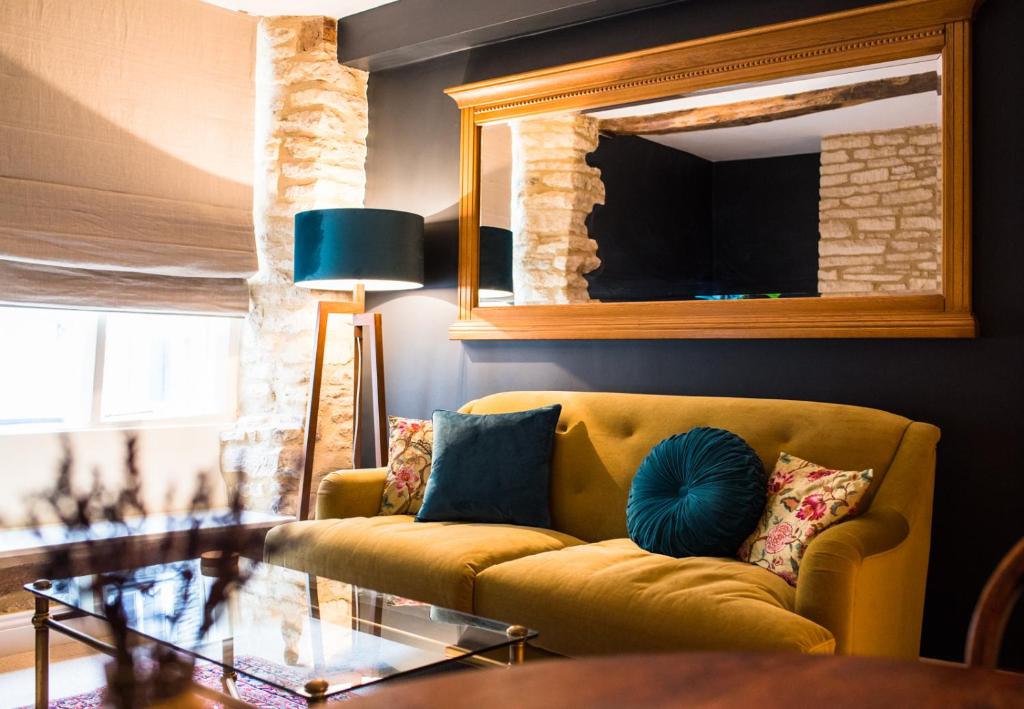 赛伦塞斯特Cotswold Place的客厅配有黄色沙发和镜子