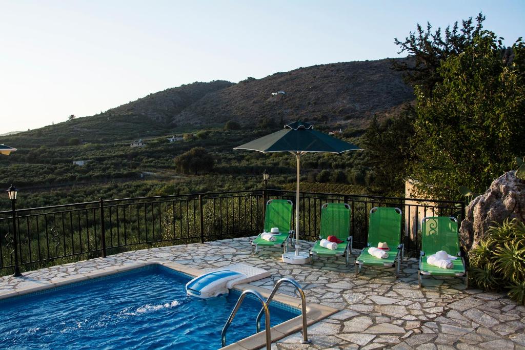 Kalamitsi AmygdaliVilla Manos的一个带草坪椅和遮阳伞的游泳池