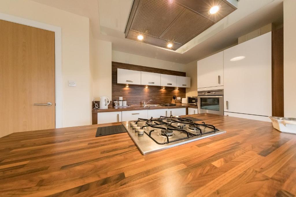 珀斯The Broch, 1st Floor, Luxurious City Centre Apartment的铺有木地板,设有带炉灶的厨房。