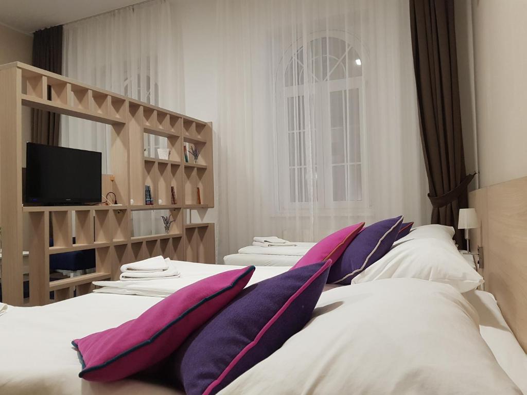 萨拉热窝往事旅舍的一间卧室配有两张带枕头的床和电视