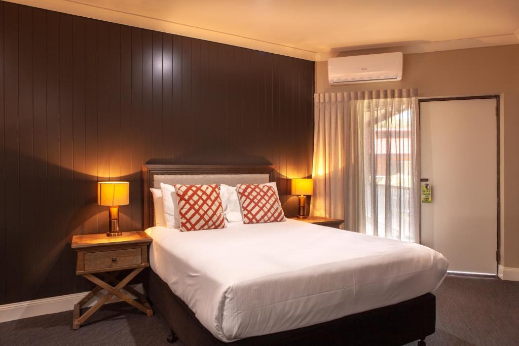 诺拉Nightcap at Archer Hotel的一间卧室配有一张大床和两张台灯。