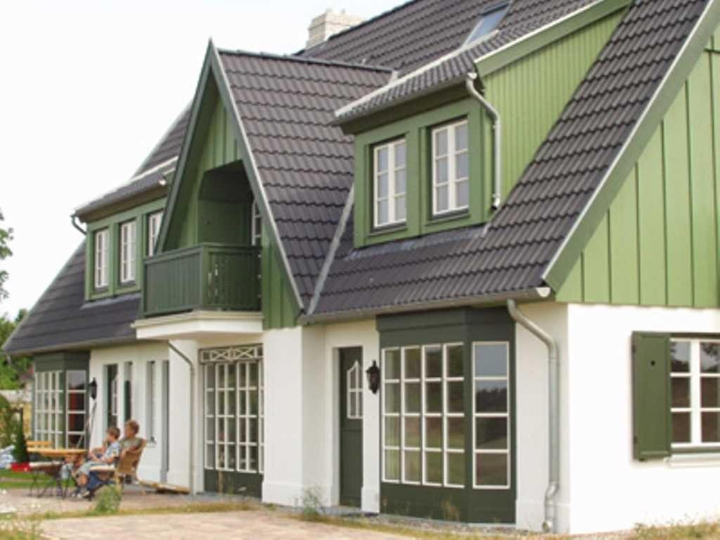 于克里茨Haus am Achterwasser Whg "Kapitän Nemo"的绿白的房子,人们坐在那里