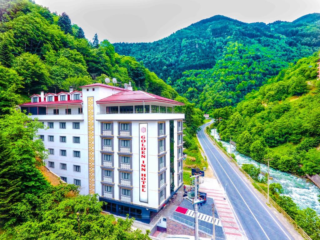 乌宗Golden Inn Hotel Uzungöl的山坡上有路的建筑物