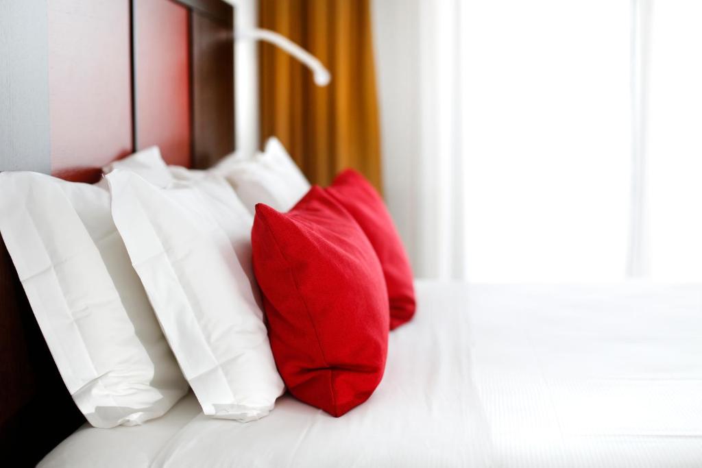 维洛尔巴假日拉马卡酒店的床上的一组红色和白色枕头