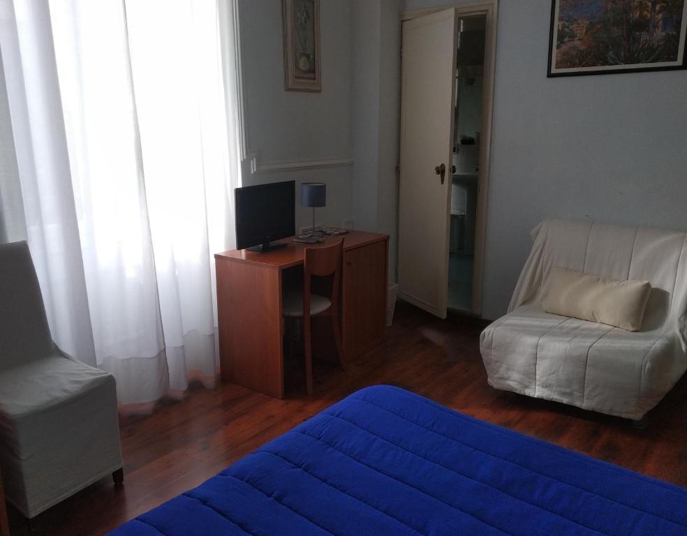 博尔迪盖拉Hotel Lucciola的客厅配有沙发和书桌及电视