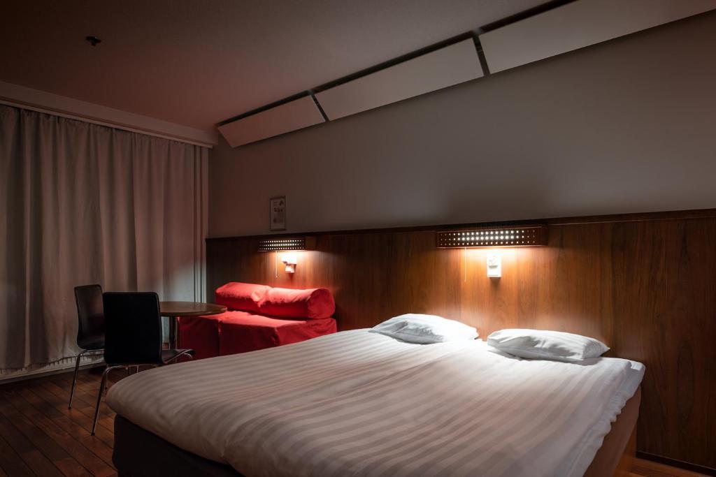 于韦斯屈莱韦斯屈莱欧美娜酒店的酒店客房设有一张大床和一张书桌。