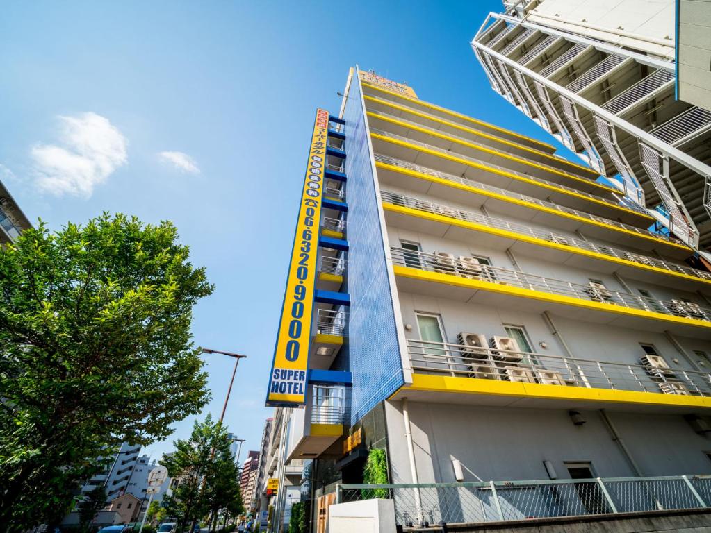 大阪新大阪东口超级酒店的建筑的侧面有黄色标志