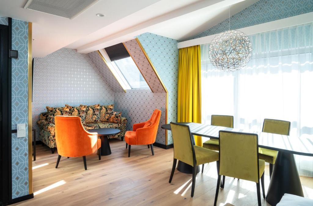 奥斯陆瑟斯而桐酒店的用餐室配有橙色椅子和桌子