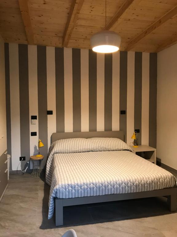 StazzanoIl fienile b&b的一间卧室配有一张床和条纹墙