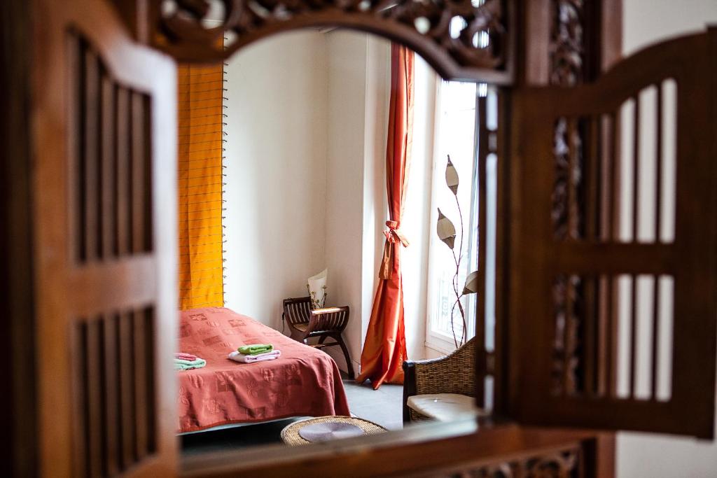 尼斯尼斯海滨甜蜜之家酒店的一间卧室设有红色的床和窗户。