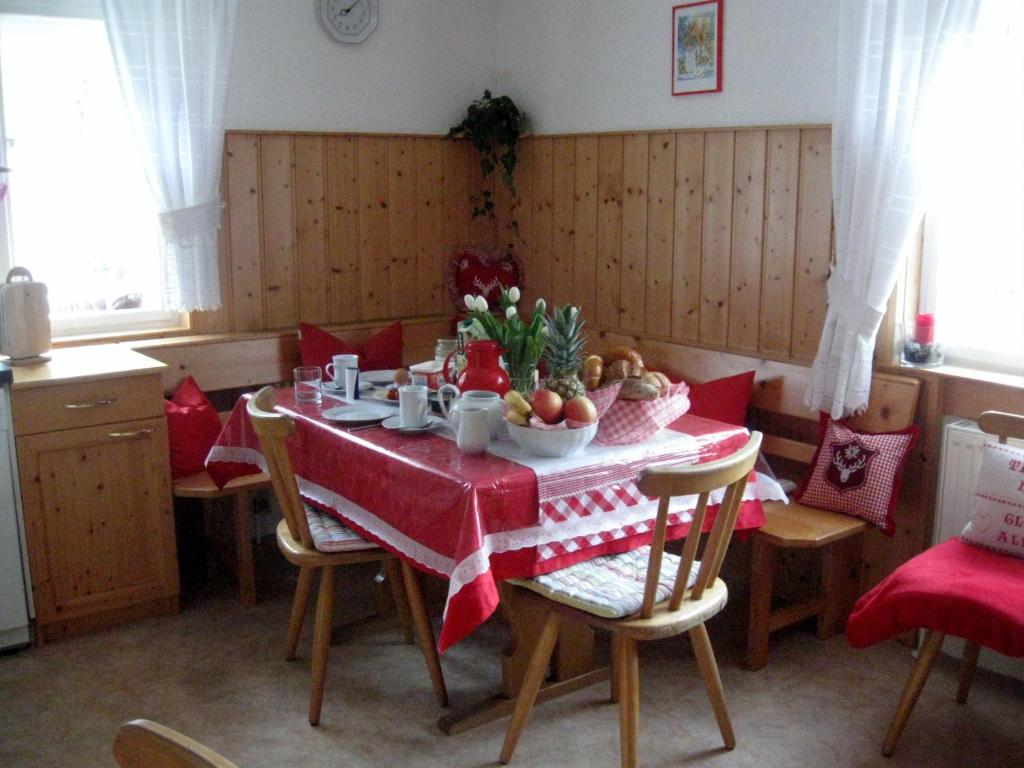 加舒恩豪斯克林格酒店的一间带红色桌布的餐桌的用餐室